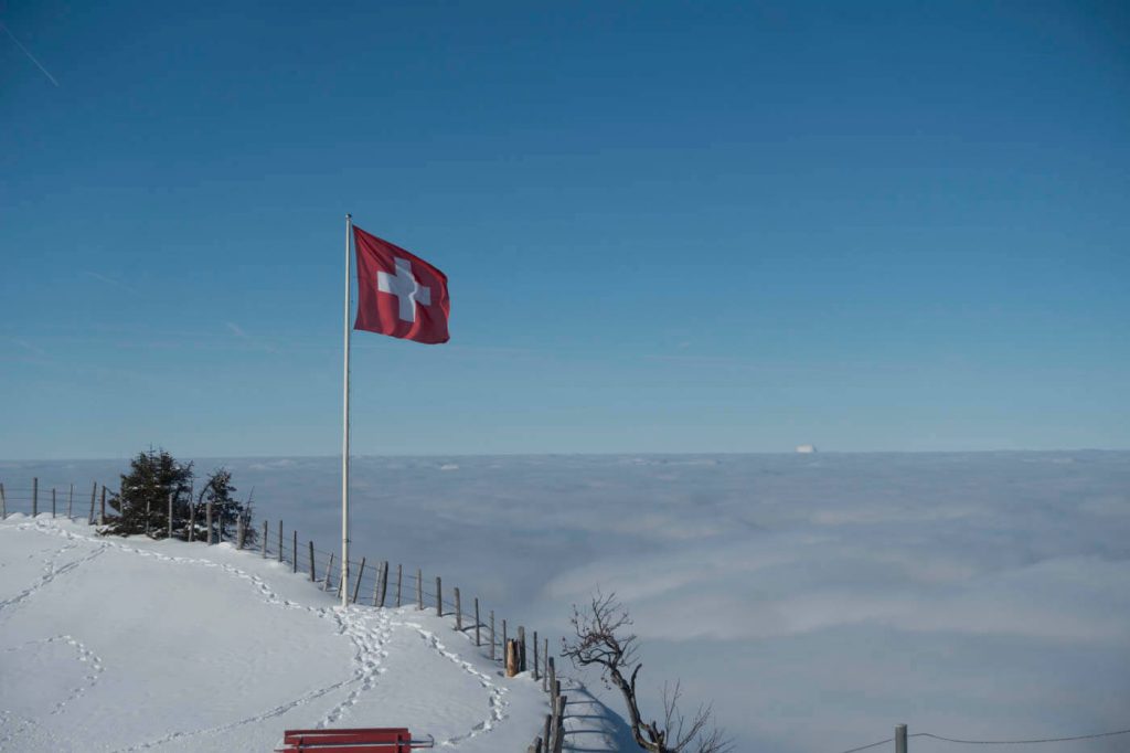 schweizer flagge ueber den wolken